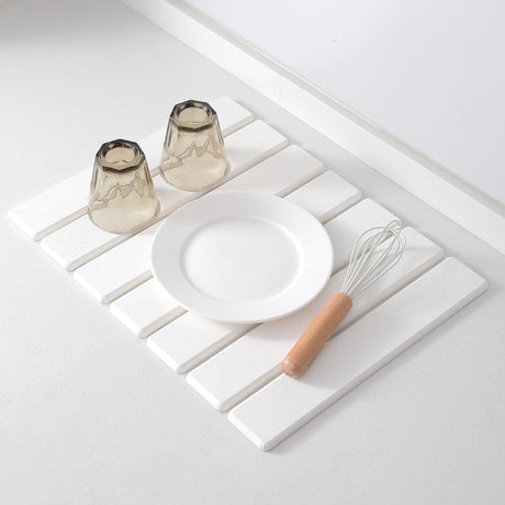 Washed glasses draining on the white diatomaceous earth countertop mat