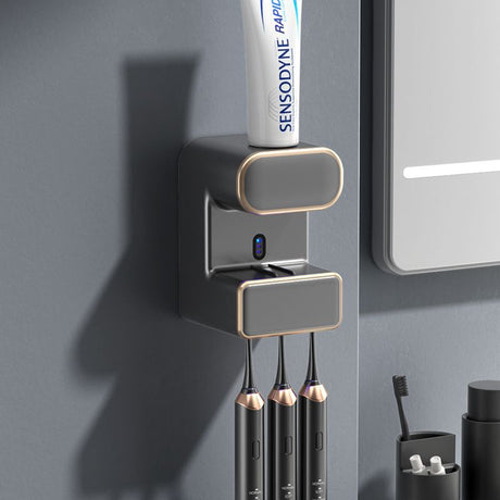 Grey wall mounted automatic toothpaste dispenser with UV steriliser and toothbrush holder