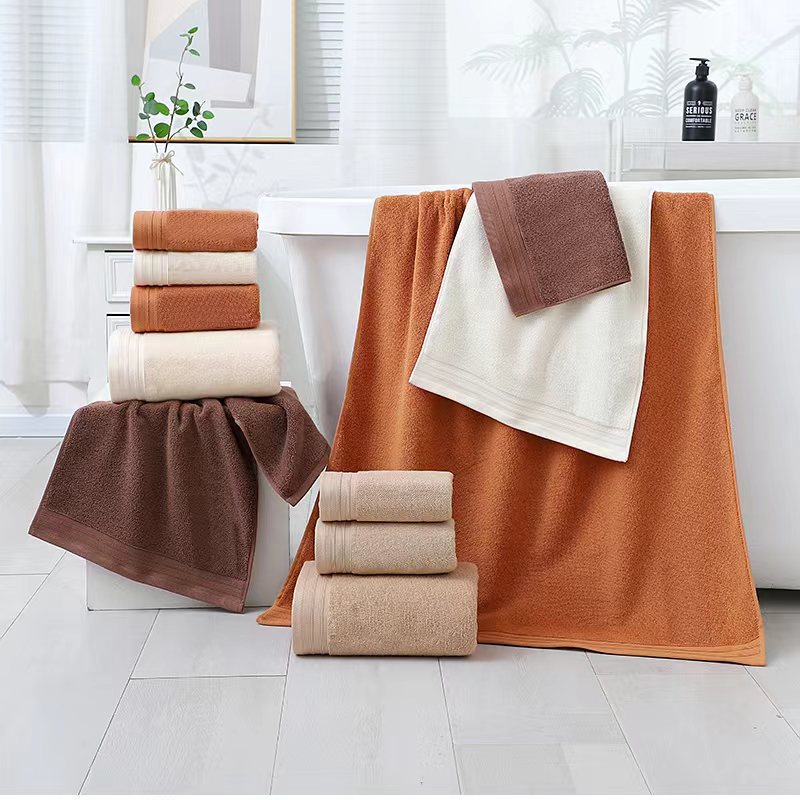 Beige combed cotton towels folded and stacked showing dobby border