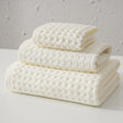 Three piece white waffle weave cotton towel set with bath towel, hand towel and washcloth