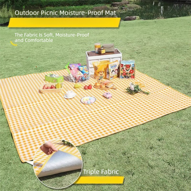 Grange yellow lightweight picnic mat 2 x 2m folded beside its drawstring bag showing printed top and reflective aluminium foil base