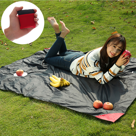 Dark blue compact pocket picnic blanket in use outdoors