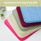 Khaki bath mat laid along the side of a bath in a tiled bathroom