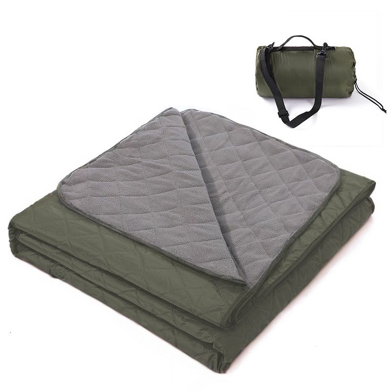 Grasmere double layer fleece picnic blanket in dark green folded beside its zippered shoulder carry bag on grass