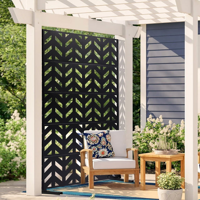 Black five panel metal privacy screen standing freely on a paved patio