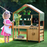 Child playing at wooden mud kitchen outdoors