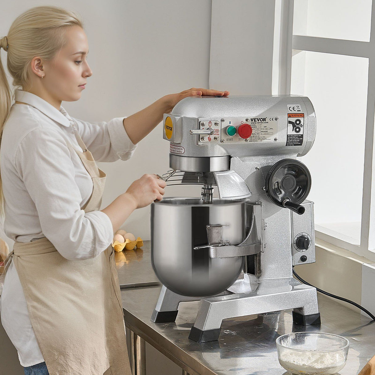 Wire whisk whipping cream in the stainless steel bowl